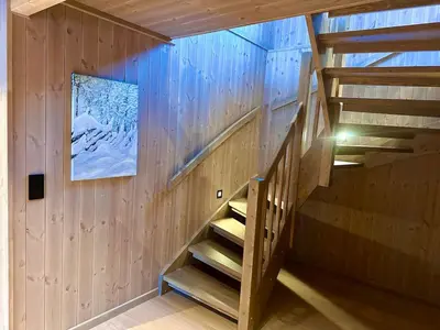 a wooden staircase in a building with a picture on the wall at Immaculate Cabin in the Heart of Beitostølen in Beitostøl