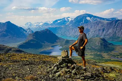 a man sitting on a rock on top of a mountain at Immaculate Cabin in the Heart of Beitostølen in Beitostøl
