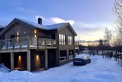 a house with a car parked in the snow at Immaculate Cabin in the Heart of Beitostølen in Beitostøl