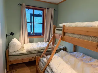 a room with three bunk beds and a window at Family-Friendly Stay With Stunning Mountain Views! in Beitostøl