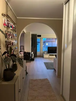 a living room with an archway and a living room with a plant at Horizontal half at Byaasen in Trondheim