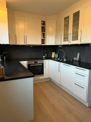 a kitchen with white cabinets and black counter tops at Horizontal half at Byaasen in Trondheim