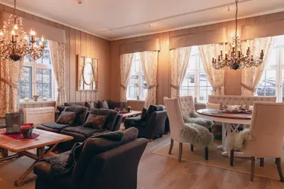 a living room with a couch and a table and chairs at Solheimen konferansehotell AS in Hedalen