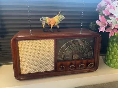 a small toy cow sitting on top of an old radio at Trollstova in Sogndal