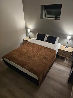a bedroom with a large bed with two night stands at Trollstova in Sogndal