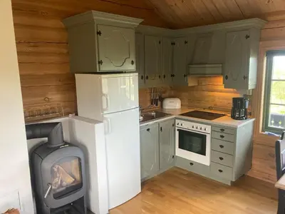 a kitchen with a stove and a white refrigerator at Hytteperle Gålå, Vakre Lauvåsen, Hønhuset in Sør-Fron