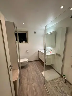 a bathroom with a shower and a toilet and a sink at Leilighet på Byåsen, i nærheten av Granåsen in Trondheim