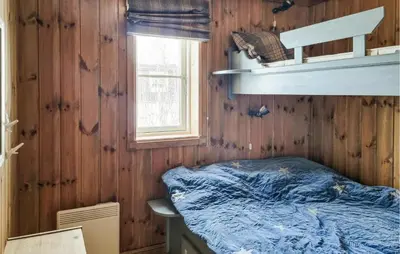 a bedroom with a bed in a wooden wall at Gorgeous Home In Vang I Valdres in Vang I Valdres
