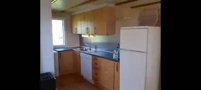 a kitchen with a white refrigerator and wooden cabinets at Holiday house by Lake Mjosa, 4 beds in Eidsvoll