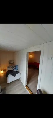 a small room with a bed in the corner of a room at Huset med utsikt til innsjøen -8 min til Gjøvik sentrum in Gjøvik