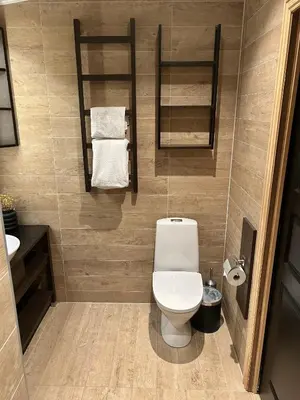 a bathroom with a toilet and a sink and towels at Cabin by the fjord in Geiranger