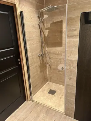 a shower with a glass door in a bathroom at Cabin by the fjord in Geiranger