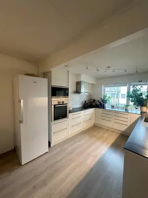 a large kitchen with a white refrigerator in a room at House near Granåsen Ski Arena in Trondheim
