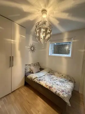 a bedroom with a bed and a chandelier at House near Granåsen Ski Arena in Trondheim