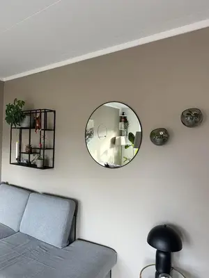 a living room with a couch and a mirror at House near Granåsen Ski Arena in Trondheim
