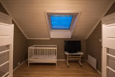 a small room with a crib and a tv at Bakkebyvegen 15B in Trysil