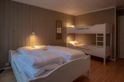 a bedroom with two bunk beds with white sheets at Bakkebyvegen 15B in Trysil