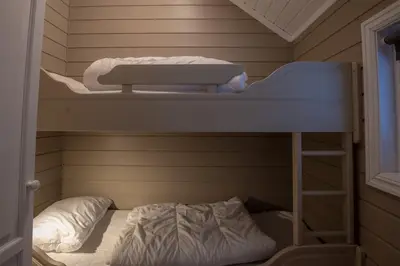 a bunk bed with a ladder and a bunk bed in a room at Bakkebyvegen 15A in Trysil