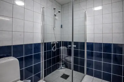 a bathroom with a shower with blue and white tiles at Bakkebyvegen 15A in Trysil