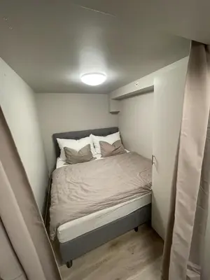 a small bedroom with a bed in a small room at Newly renovated apartment in the middle of Trondheim city centre in Trondheim