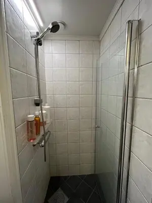 a shower with a glass door in a bathroom at Top floor, cozy apartment, centrally located in Trondheim in Trondheim
