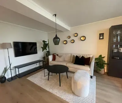 a living room with a couch and a table at Newly renovated apartment for rent in Stjoerdal