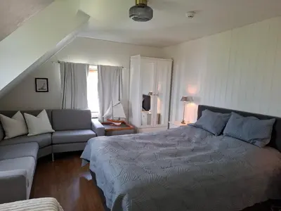 a bedroom with a bed and a couch at Close to the Airport and Trondheim in Malvik