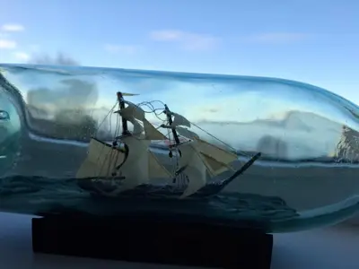 a glass bottle with a sail boat in it at Close to the Airport and Trondheim in Malvik