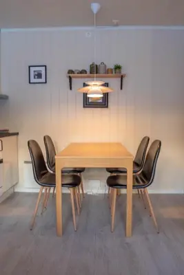 a dining room table with black chairs around it at Alpinlandsbyen - Ski in - Ski out -Nr 34 in Hafjell