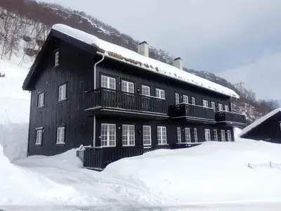 a large black building with snow on top of it at Mountain view 1 in Håra
