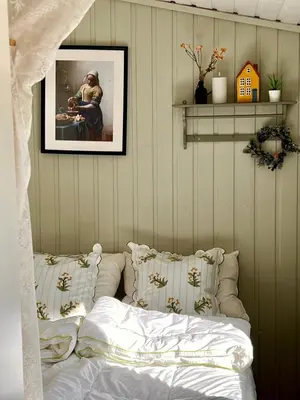 a bedroom with a bed with pillows and a picture at Veslekoia - Grandmas Cabin in Øksna