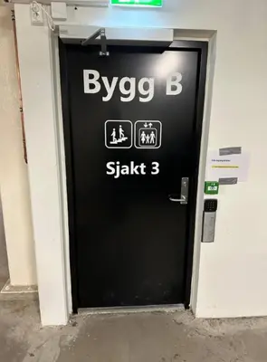 a black door with a sign on it in a building at Cozy ski in & out apartment in Kyrkjebøen