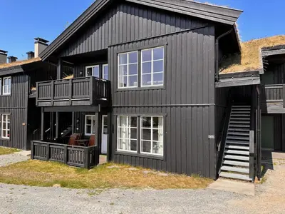 a black house with a porch and a balcony at Beitotind 1504 in Beitostøl