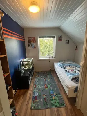 a small bedroom with a bed and a rug at Older Villa with large garden in Trondheim