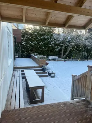 a patio with benches on a deck with a playground at Older Villa with large garden in Trondheim