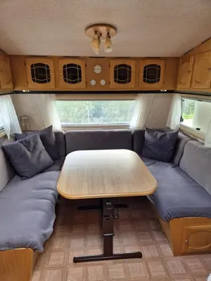 a table and couch in the back of a caravan at Trysil Campingvogn Ski in-out in Trysil