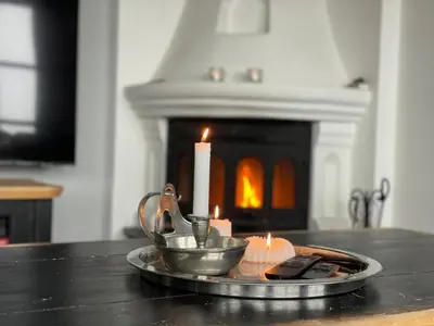 a tray with a candle and a candle holder on a table with a fireplace at Cozy Top-Floor Apartment With Fireplace And Sauna in Beitostøl