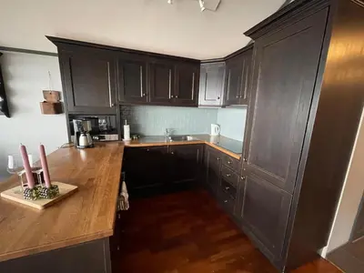 a kitchen with brown cabinets and a wooden counter top at Cozy Top-Floor Apartment With Fireplace And Sauna in Beitostøl