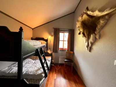 a room with two bunk beds and aanimal head on the wall at Cozy Top-Floor Apartment With Fireplace And Sauna in Beitostøl