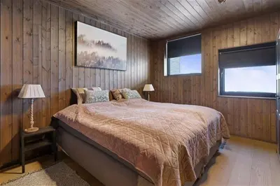 a bedroom with a large bed and two windows at Ski in-out - 3BR, 2 Bath Chalet apartment - Favn Hafjell in Hafjell