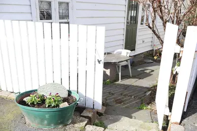 a plant in a pot next to a white fence at DINBNB Homes l Charming 2-Bedroom Home by the Sea Cozy in Bergen