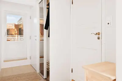 a white hallway with a door and a mirror at 200m to Torgalmenningen & 20 sqm terrace in Bergen