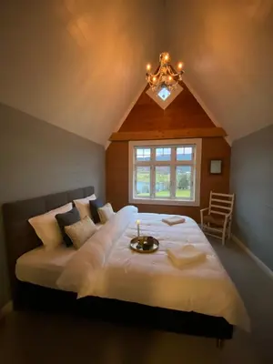 a bedroom with a large bed with a candle on it at Holiday house Vindafjord Norway in Ølsvågen