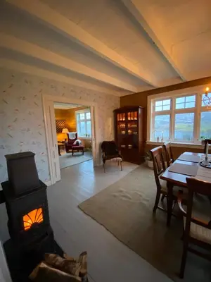 a living room with a wood stove and a table at Holiday house Vindafjord Norway in Ølsvågen