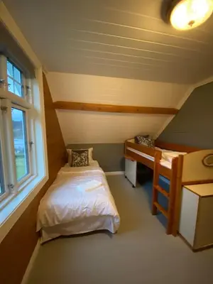 a small room with two beds and a desk at Holiday house Vindafjord Norway in Ølsvågen