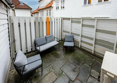 a patio with two chairs and a fence at Modern Apartment in 1840-Building at Nordnes in Bergen