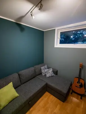 a living room with a couch and a guitar at Spacious house, close to Granåsen Ski Arena! 4 beds, 2 bathrooms, free parking in Trondheim