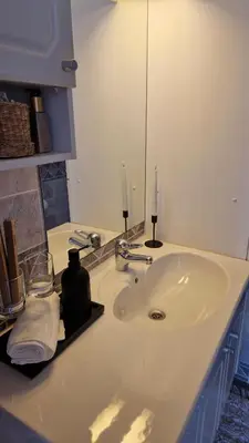 a bathroom sink with two candles on top of it at Jugend City Retreat - Ålesund Apartment in Ålesund