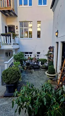 a courtyard with plants in front of a building at Jugend City Retreat - Ålesund Apartment in Ålesund