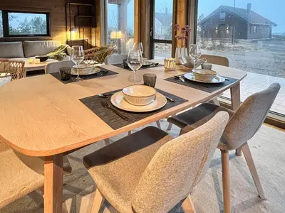 a wooden table with chairs and a dining room at 6 person holiday home in Averøya in Karvåg
